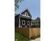 A charming two-story home with gray siding, natural wood accents, white framed windows, and a tall wood fence at 350 E Minnesota St, Indianapolis, IN 46225