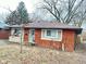 Exterior view of a brick home featuring new windows and a cozy front porch at 4114 N Butler Ave, Indianapolis, IN 46226