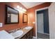 Bathroom featuring double sinks with a mirror, lighting fixture and door at 5782 Jamestown Square Ln, Indianapolis, IN 46234
