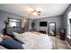 Well-lit bedroom with a comfortable bed, wood-look flooring, ceiling fan, and dark wood furniture at 5782 Jamestown Square Ln, Indianapolis, IN 46234