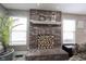Close-up of a beautiful brick fireplace with decorative mantel, wood storage, and natural light at 5782 Jamestown Square Ln, Indianapolis, IN 46234