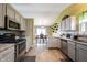 Open concept kitchen with stainless steel appliances, gray cabinets and view to dining area at 5782 Jamestown Square Ln, Indianapolis, IN 46234