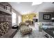 Inviting living room featuring a brick fireplace and unique accent chair, open to the dining area at 5782 Jamestown Square Ln, Indianapolis, IN 46234