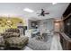 Open living room boasts a cozy sectional sofa, ceiling fan, and natural light from skylights at 5782 Jamestown Square Ln, Indianapolis, IN 46234