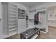 Spacious walk-in closet features custom shelving and drawers, with an ottoman and views into the bathroom at 5802 Watson Rd, Greenwood, IN 46143