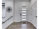 Bright foyer showcasing wood-look flooring, a modern front door, and a staircase with an elegant wall decoration at 5802 Watson Rd, Greenwood, IN 46143