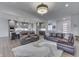 Bright, open-concept living room with hardwood floors, modern lighting, and comfortable leather seating at 5802 Watson Rd, Greenwood, IN 46143