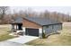 Striking rear exterior shot of a modern home showing the two-car garage and well-manicured backyard at 5802 Watson Rd, Greenwood, IN 46143