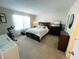 This bedroom features a large bed, dark wood furniture, and a window with white curtains at 5850 Bradston Way, Indianapolis, IN 46237