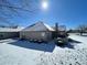 Back exterior view of home featuring brick, chimney, fence and landscaped yard covered in winter snow at 5850 Bradston Way, Indianapolis, IN 46237