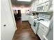 Bright kitchen with white cabinets and appliances adjacent to the living room and dining areas at 5850 Bradston Way, Indianapolis, IN 46237