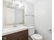 Simple bathroom with a brown vanity, white toilet, and a large mirror at 6354 River Run Dr, Indianapolis, IN 46221