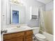 Bathroom with wood vanity, linen cabinet and tub at 6354 River Run Dr, Indianapolis, IN 46221