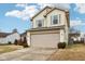 Two-story house with beige siding, red brick, and a two-car garage at 6354 River Run Dr, Indianapolis, IN 46221