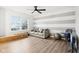 Living room with gray and white striped accent wall, ceiling fan and large window at 6354 River Run Dr, Indianapolis, IN 46221
