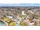 An aerial view of a neighborhood featuring houses and trees surrounding a tranquil pond at 6530 Duck Pond Dr, Fishers, IN 46038