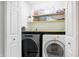 Efficient laundry room with washer, dryer, and convenient shelving for storage at 6530 Duck Pond Dr, Fishers, IN 46038