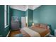 Cozy bedroom with teal walls, double bed, and dresser at 714 Buchanan St # 5, Indianapolis, IN 46203
