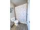 Bathroom with floral shower curtain and wood-look tile floors at 8139 Hi Vu Dr, Indianapolis, IN 46227