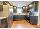 Modern kitchen with dark cabinets, granite counters, and stainless steel appliances at 8139 Hi Vu Dr, Indianapolis, IN 46227