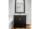A bathroom featuring a dark vanity with a white countertop and a framed mirror at 8815 Frontenac Rd, Indianapolis, IN 46226