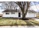 Charming single-story home with white siding, black door, and an attached one car garage at 8815 Frontenac Rd, Indianapolis, IN 46226