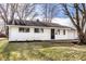 Charming single-story home with white siding, black door, and an attached one car garage at 8815 Frontenac Rd, Indianapolis, IN 46226