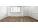 Bright living room with wood-look flooring, white walls, a door and modern window at 8815 Frontenac Rd, Indianapolis, IN 46226