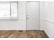 Bright living room with wood-look flooring, white walls, a door and modern window at 8815 Frontenac Rd, Indianapolis, IN 46226
