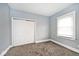 Bedroom with gray walls, gray carpet, and a double door closet at 1058 N Holmes Ave, Indianapolis, IN 46222