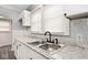 White cabinets, granite countertops, and a stainless steel double sink at 1058 N Holmes Ave, Indianapolis, IN 46222