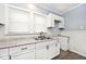 White kitchen with granite countertops and herringbone backsplash at 1058 N Holmes Ave, Indianapolis, IN 46222