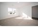 Bright bedroom featuring neutral carpeting, large window, and a glimpse of hardwood flooring in the closet at 1132 Fleming Dr, Greenfield, IN 46140