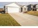 A charming single-story home features a spacious driveway and well-maintained front lawn at 1132 Fleming Dr, Greenfield, IN 46140