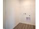 Bright laundry room featuring wood-look flooring, wire shelving, and washer/dryer hookups at 1132 Fleming Dr, Greenfield, IN 46140