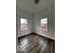 Bright bedroom with dark wood-look flooring and two windows at 1154 N Belleview Pl, Indianapolis, IN 46222