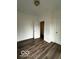 Spacious bedroom with dark wood-look flooring and an adjacent door at 1154 N Belleview Pl, Indianapolis, IN 46222