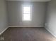 A bright bedroom with a large window, neutral walls, and neutral carpeting at 1510 Josephine St, Martinsville, IN 46151