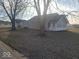View of the front exterior featuring trees, gravel driveway, and light-colored siding at 1510 Josephine St, Martinsville, IN 46151