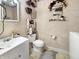 A small half-bathroom with a white toilet and sink, and decorated with floral decor at 1515 Ringgold Ave, Indianapolis, IN 46203