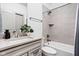 Bathroom with a tub-shower combo, stone countertop and walls, and gray cabinets at 16012 Forewood Ln, Fishers, IN 46037