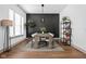 Dining room featuring a modern light fixture, rug and black accent wall with a large wooden table at 16012 Forewood Ln, Fishers, IN 46037
