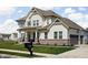 Charming home featuring white siding, a covered porch, three-car garage, and well-maintained landscaping at 16012 Forewood Ln, Fishers, IN 46037