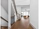 Hallway with hardwood floors, leading to the open-concept living room, featuring a staircase and stylish railing at 16012 Forewood Ln, Fishers, IN 46037