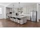 Bright kitchen boasts white cabinets, a large center island with bar stools, and stainless steel appliances at 16012 Forewood Ln, Fishers, IN 46037