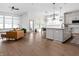 Open-concept living space with hardwood floors, modern kitchen island, and comfortable seating area at 16012 Forewood Ln, Fishers, IN 46037