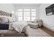 Bright main bedroom features a large window for natural light, a sitting chair with an ottoman and a large TV at 16012 Forewood Ln, Fishers, IN 46037