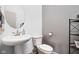 Chic powder room with pedestal sink, modern fixtures, and elegant wallpaper at 16012 Forewood Ln, Fishers, IN 46037