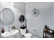 Stylish half bathroom with round mirror, decorative shelves, and modern fixtures at 16457 Anderson Way, Noblesville, IN 46062