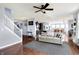 Spacious living room with hardwood floors, modern ceiling fan, and open concept to dining area and kitchen at 16457 Anderson Way, Noblesville, IN 46062